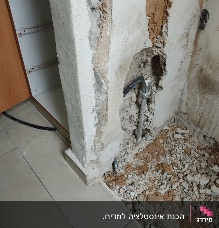 קיר שבור עם צינור מים חשוף ותשתית בנייה